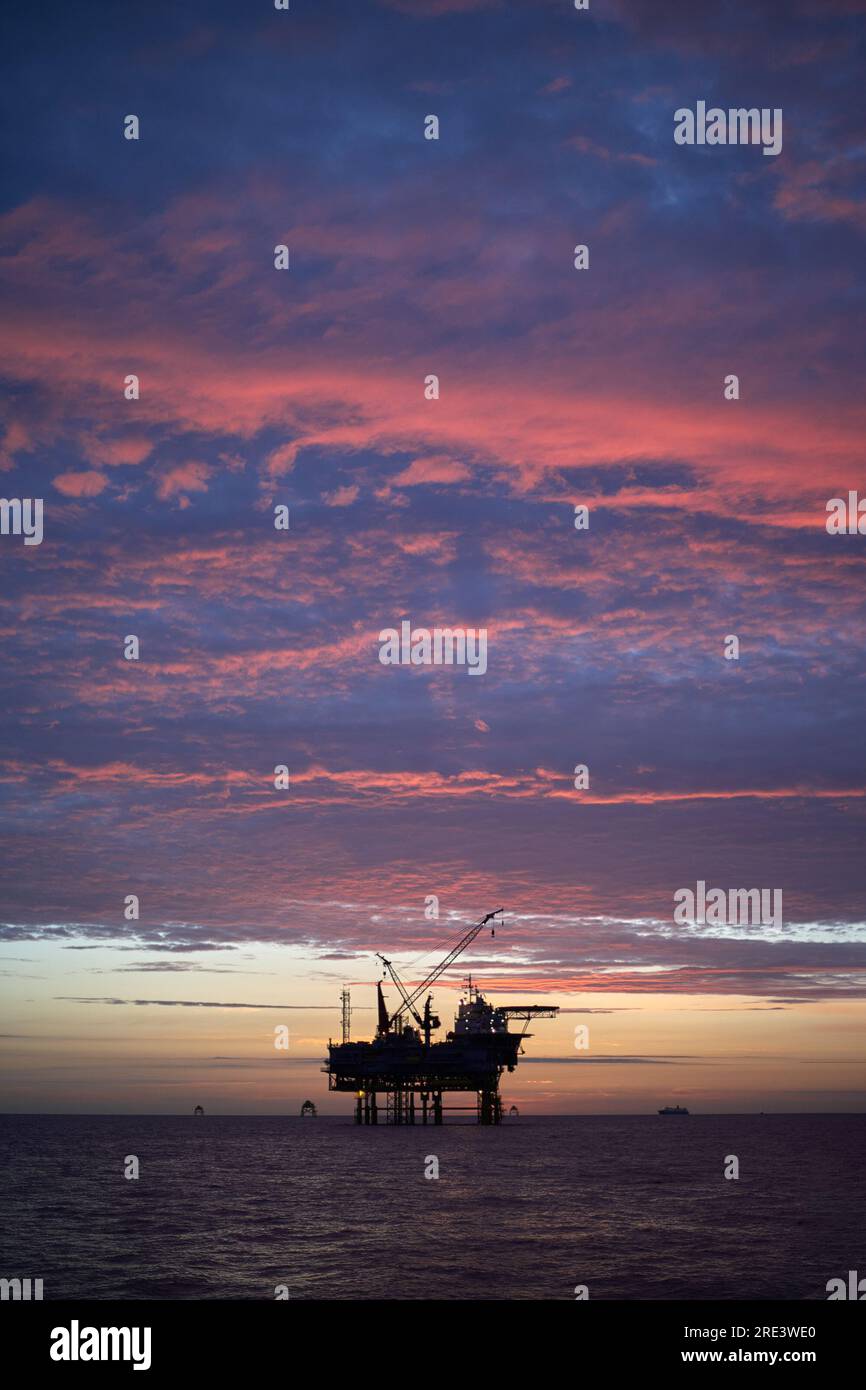 Jack up offshore platform in the sea at sunrise. Stock Photo