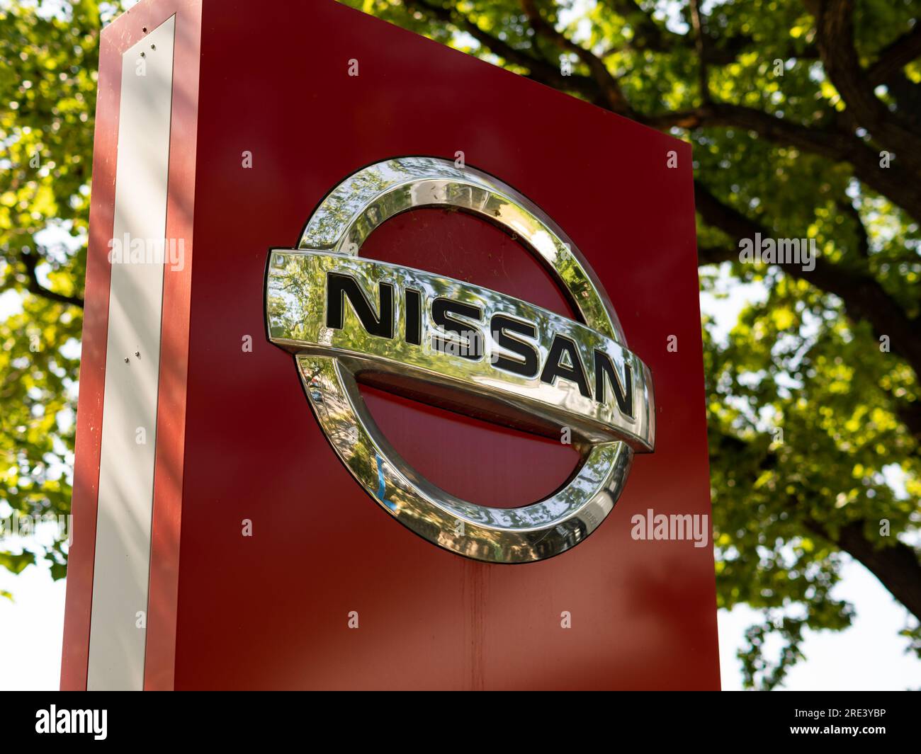 Nissan logo sign at a car dealer and service point. The Japanese automobile manufacturer is operating worldwide with the headquarters in Japan. Stock Photo