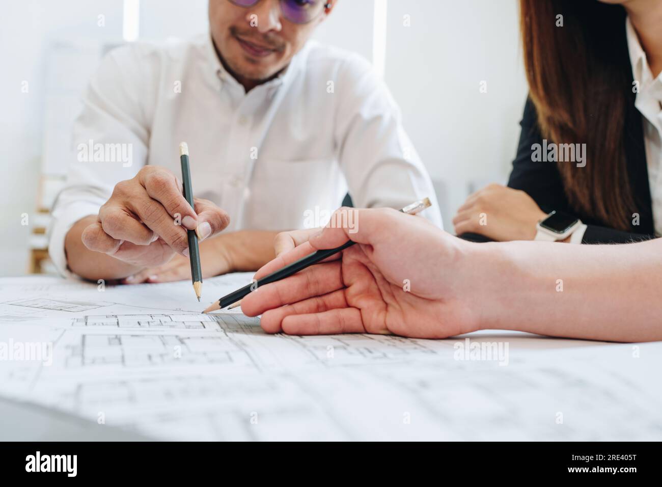 multi ethnic engineer brainstorming and measuring for cost estimating