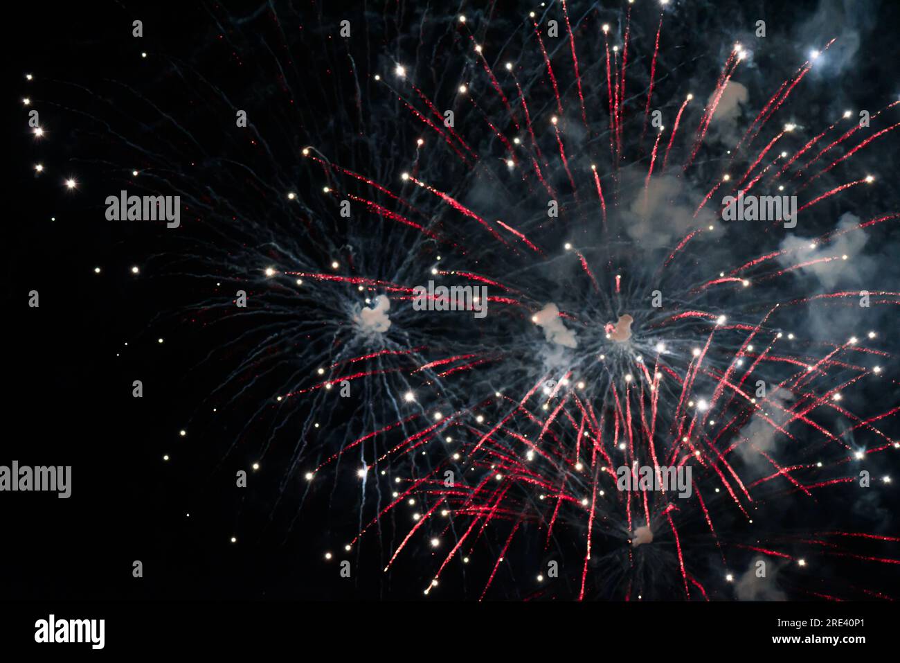 Close-up fireworks explode in the sky with motion blur on a black background. Stock Photo