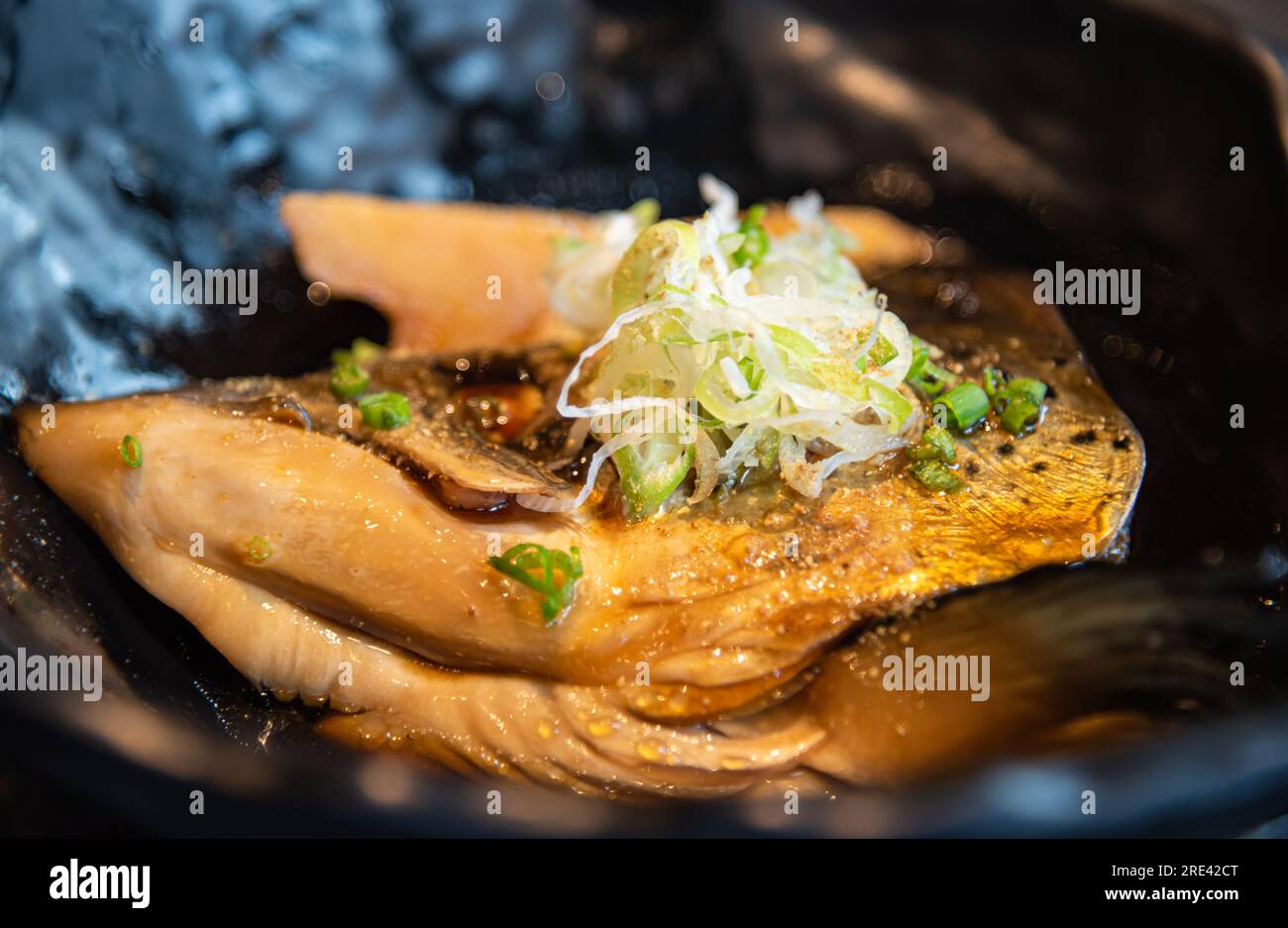 Salmon kabutoni, Salmon head in soya sauce with sliced spring onion on