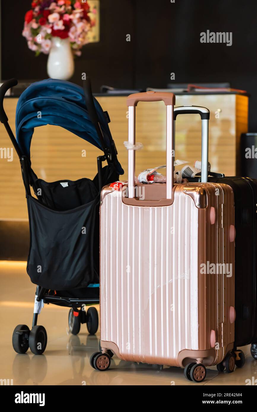 Suitcase and stroller lay in front of hotel reception Stock Photo Alamy