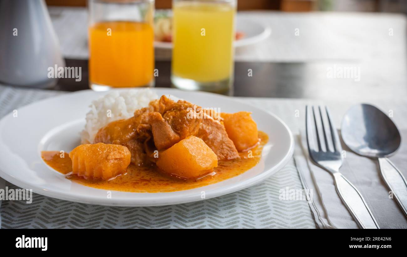 Thai massaman chicken curry with rice on wood table backgrounds Stock Photo