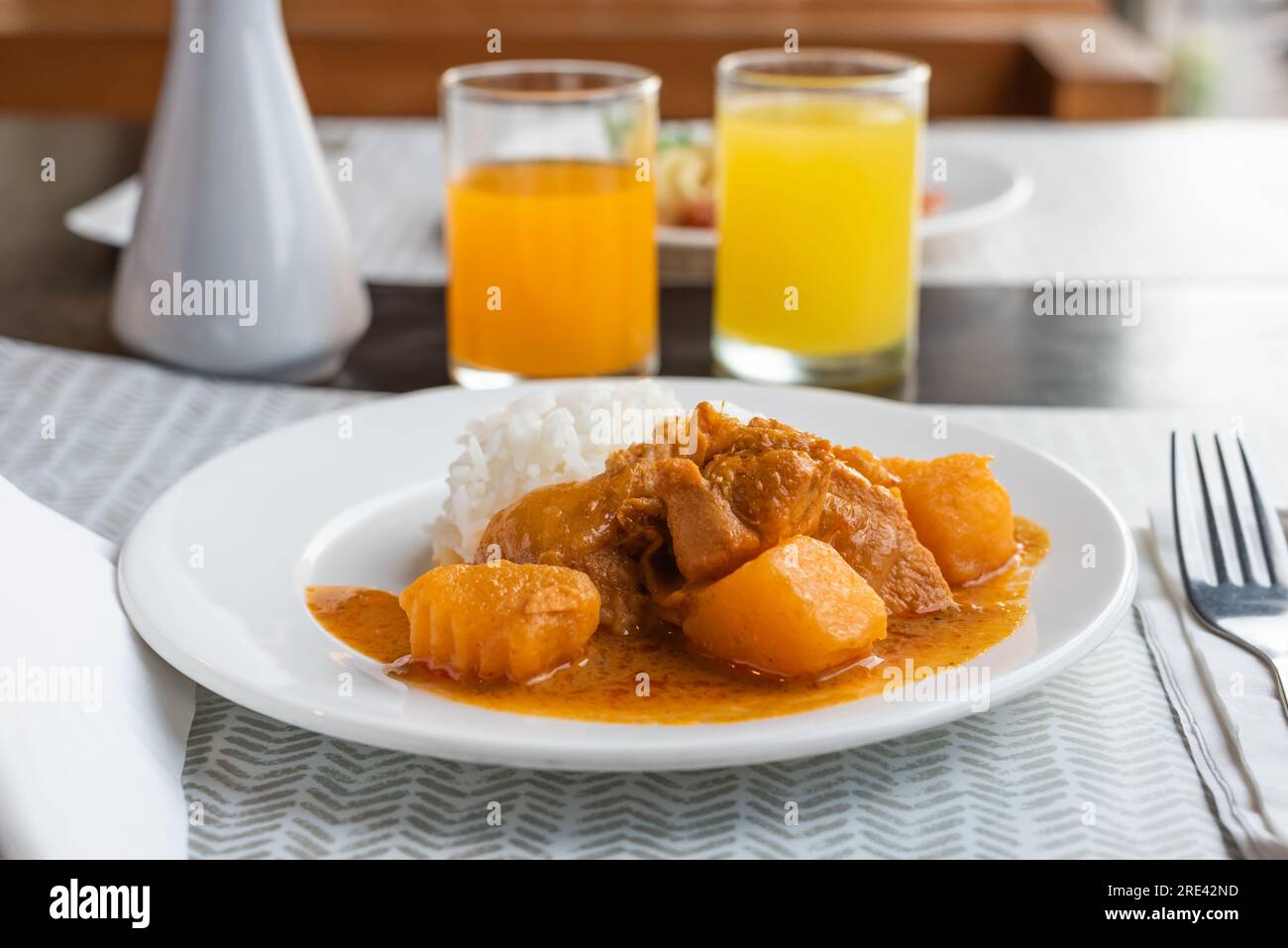 Thai massaman chicken curry with rice on wood table backgrounds Stock Photo