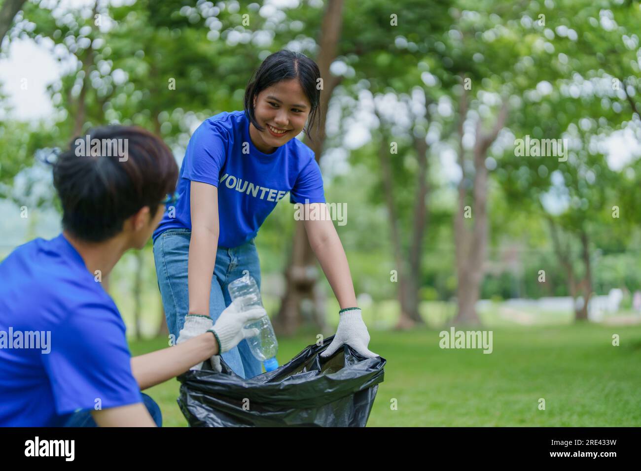 Multiethnic volunteers donate their time holding black garbage bags to