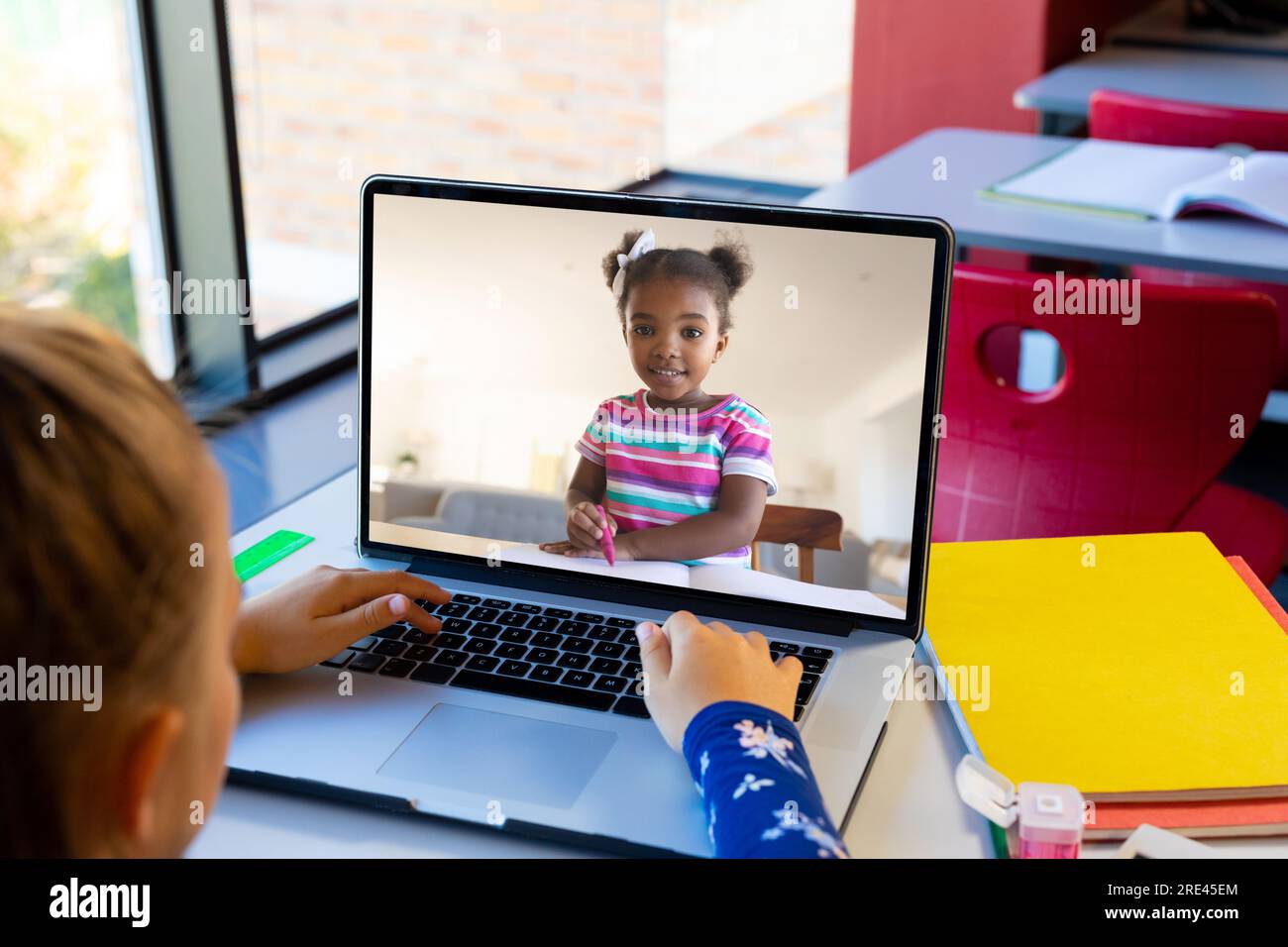 Caucasian girl using laptop while having a video call with african ...