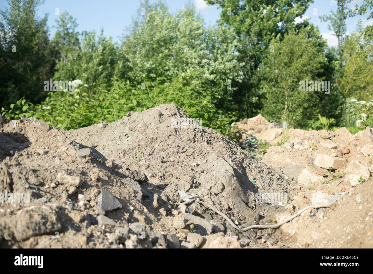 Mountain of construction debris. Excavated earth. Discarded cement. Illegal garbage dumping. Stock Photo