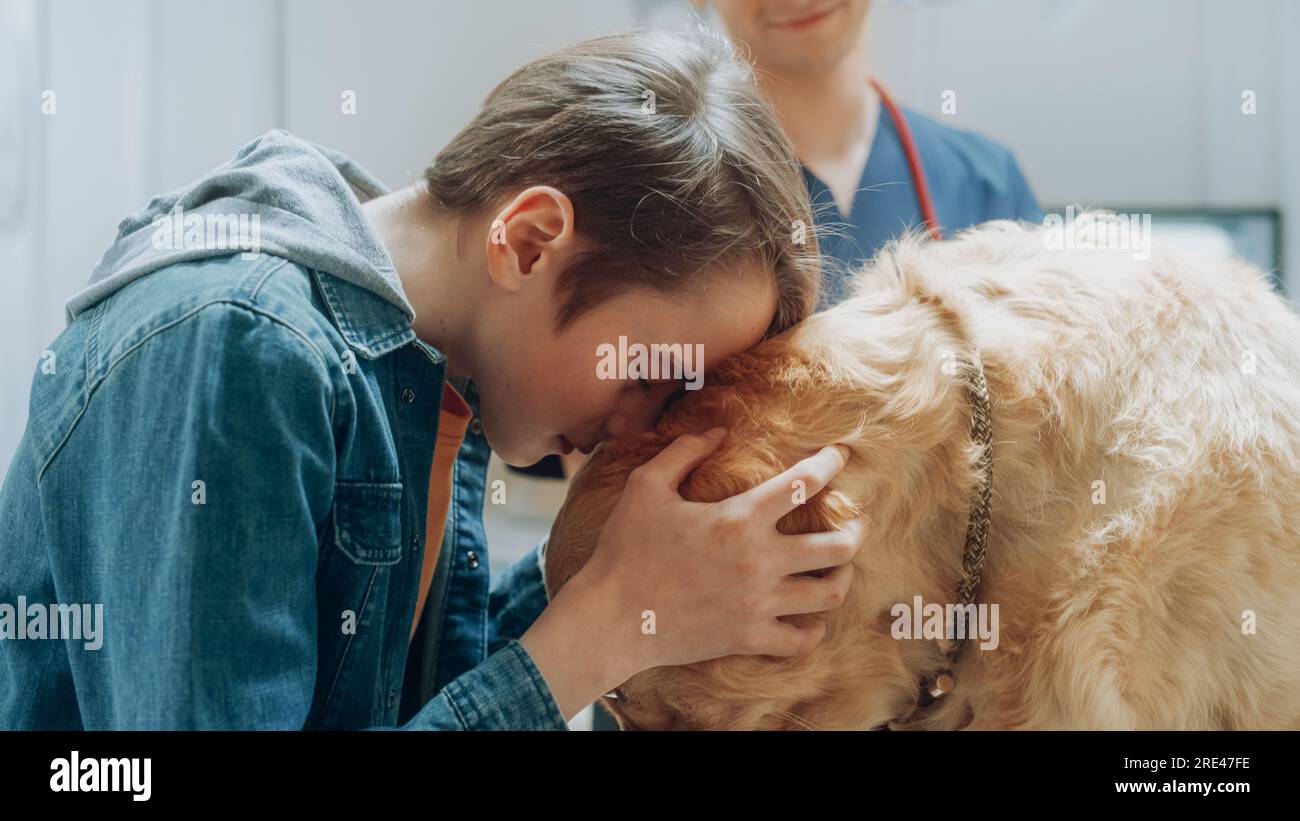 Young Boy Bonding with His Pet Golden Retriever at a Veterinary Clinic. Veterinarian Smiling, Knowing that Nothing Bad Will Happen to His Furry Friend Stock Photo