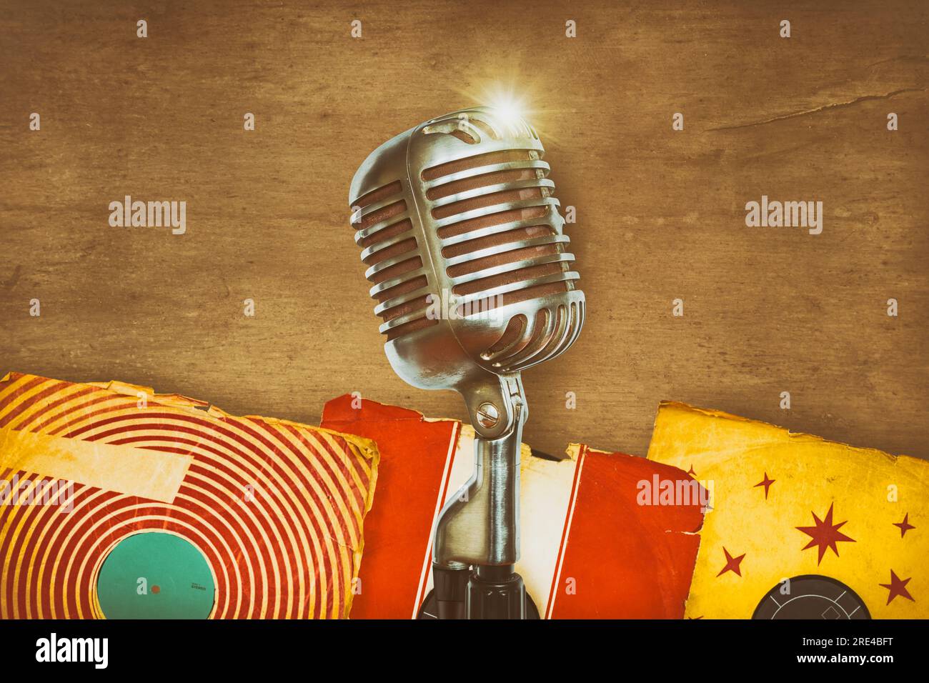 Retro styled image of an authentic vintage microphone with old record albums Stock Photo