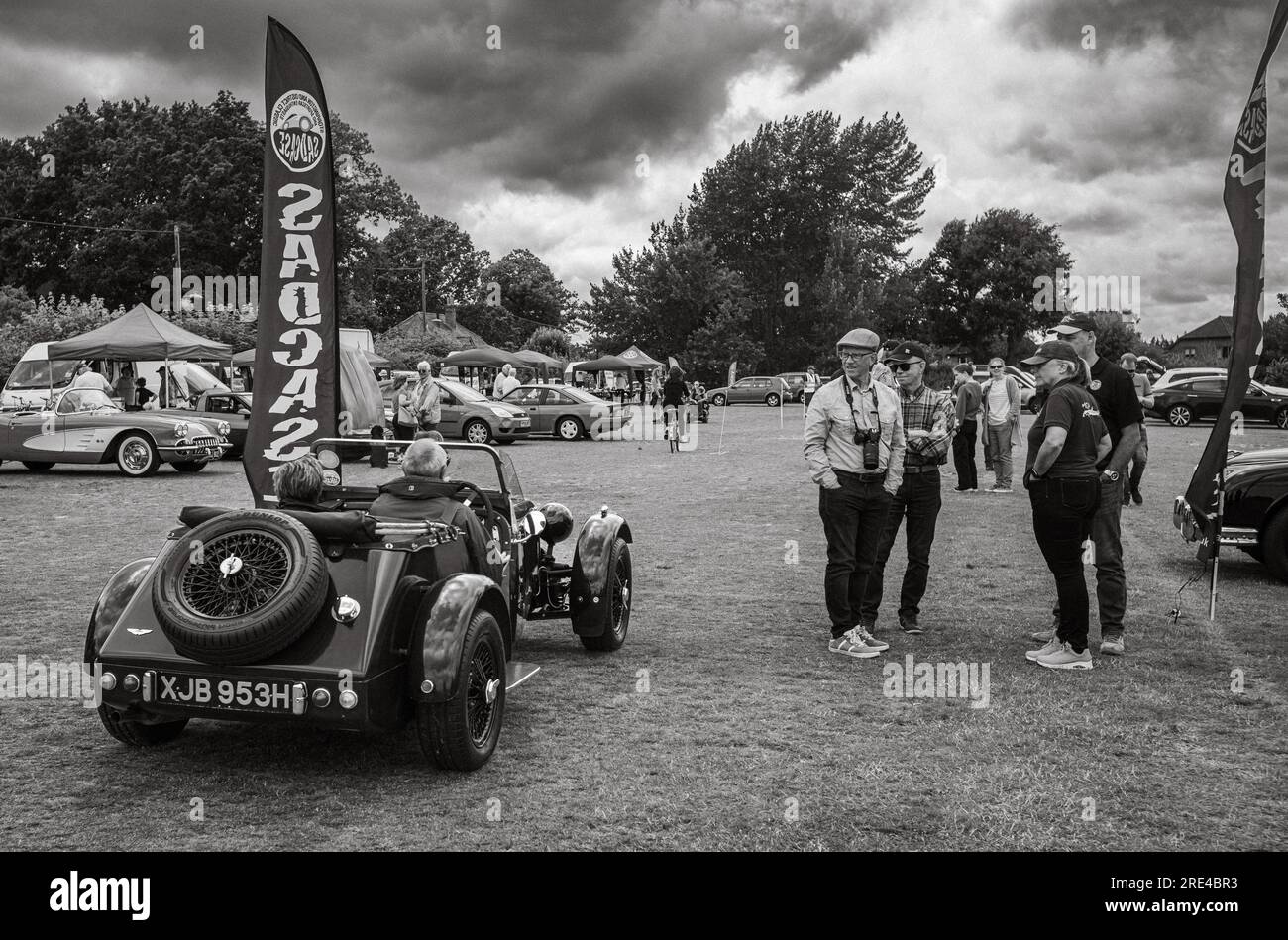 Car enthusiasts watch a participant drive his 2seater dark green NG TD
