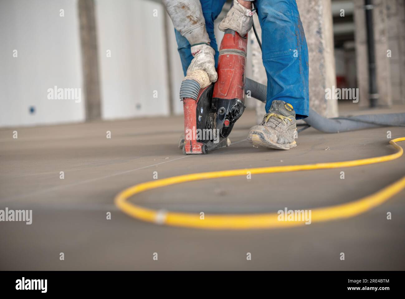 Crop site worker using concrete cutter Stock Photo