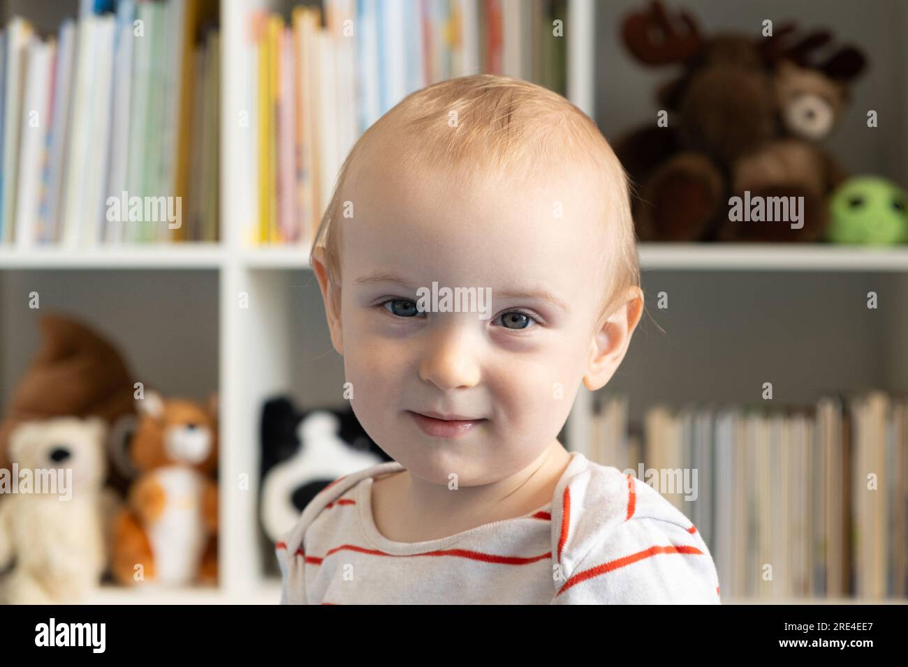 Portrait of a oneyearold baby, a blonde boy in a children's room