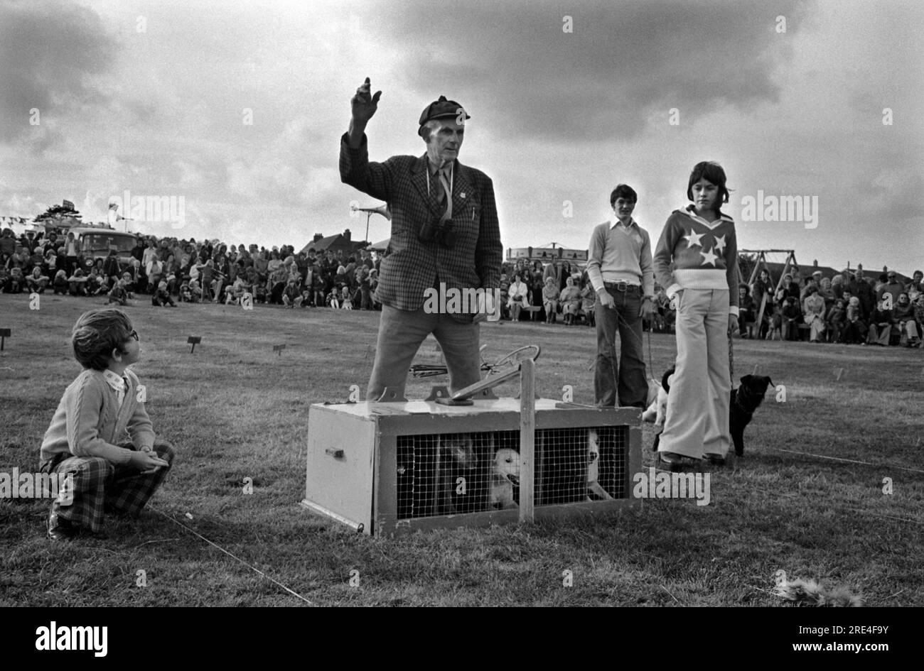 Terrier races, boys in their fashionable flared trousers called Flares, or Bellbottoms, with their pet dogs at Egremont Crabapple annual fair. The Lake District, 1975 1970s UK Egremont Cumbria HOMER SYKES Stock Photo