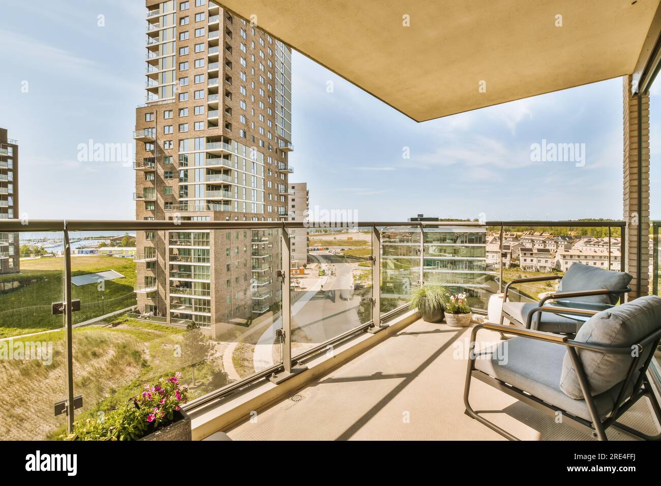 a balcony with chairs and an ocean view in the background, taken from ...