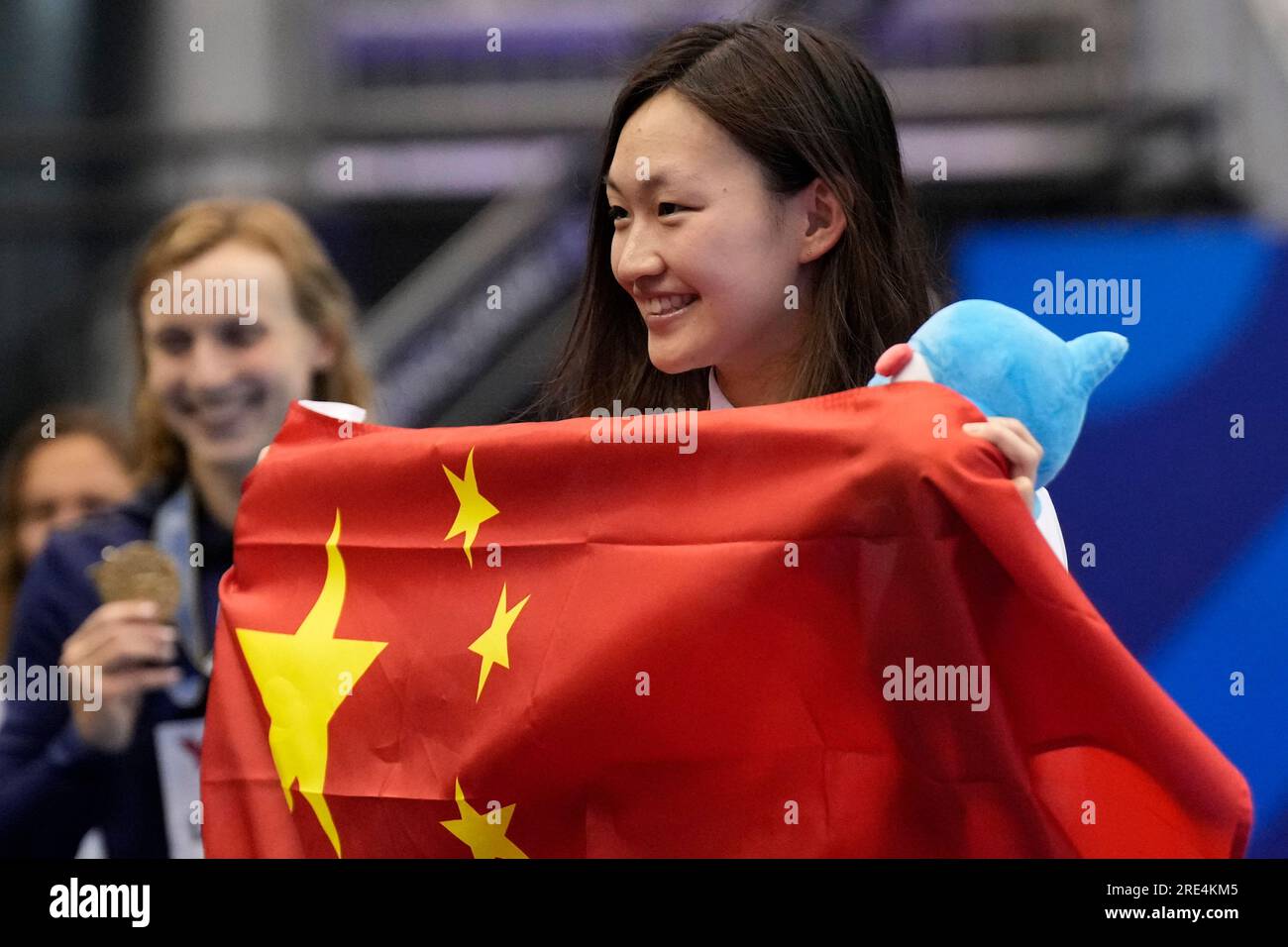 Bronze medalist Li Bingjie of China holds her flag during ceremonies at ...