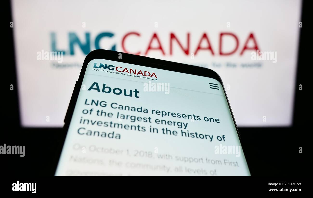Smartphone with webpage of industrial energy project LNG Canada on screen in front of logo. Focus on top-left of phone display. Stock Photo