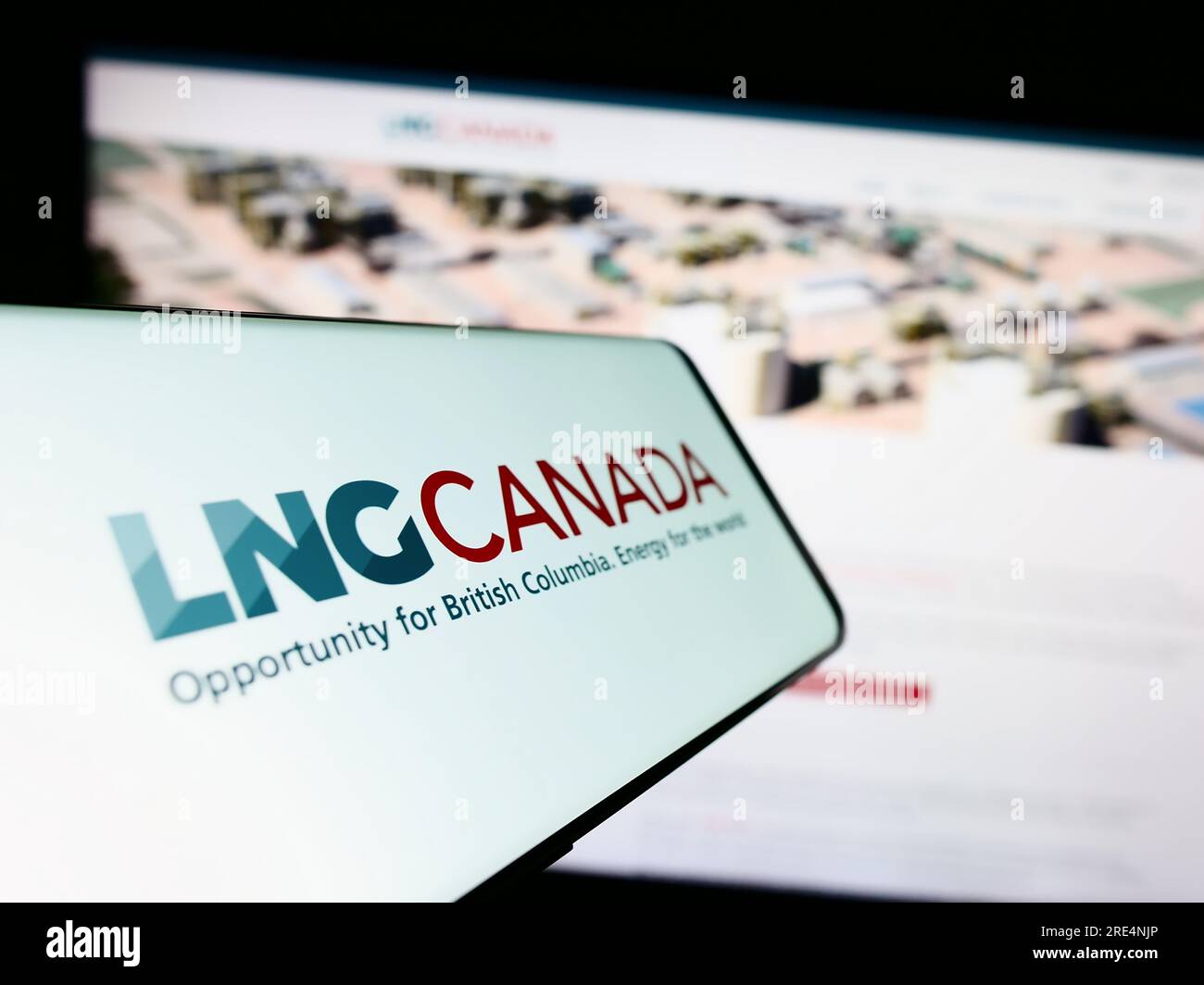 Mobile phone with logo of industrial energy project LNG Canada on screen in front of website. Focus on center of phone display. Stock Photo