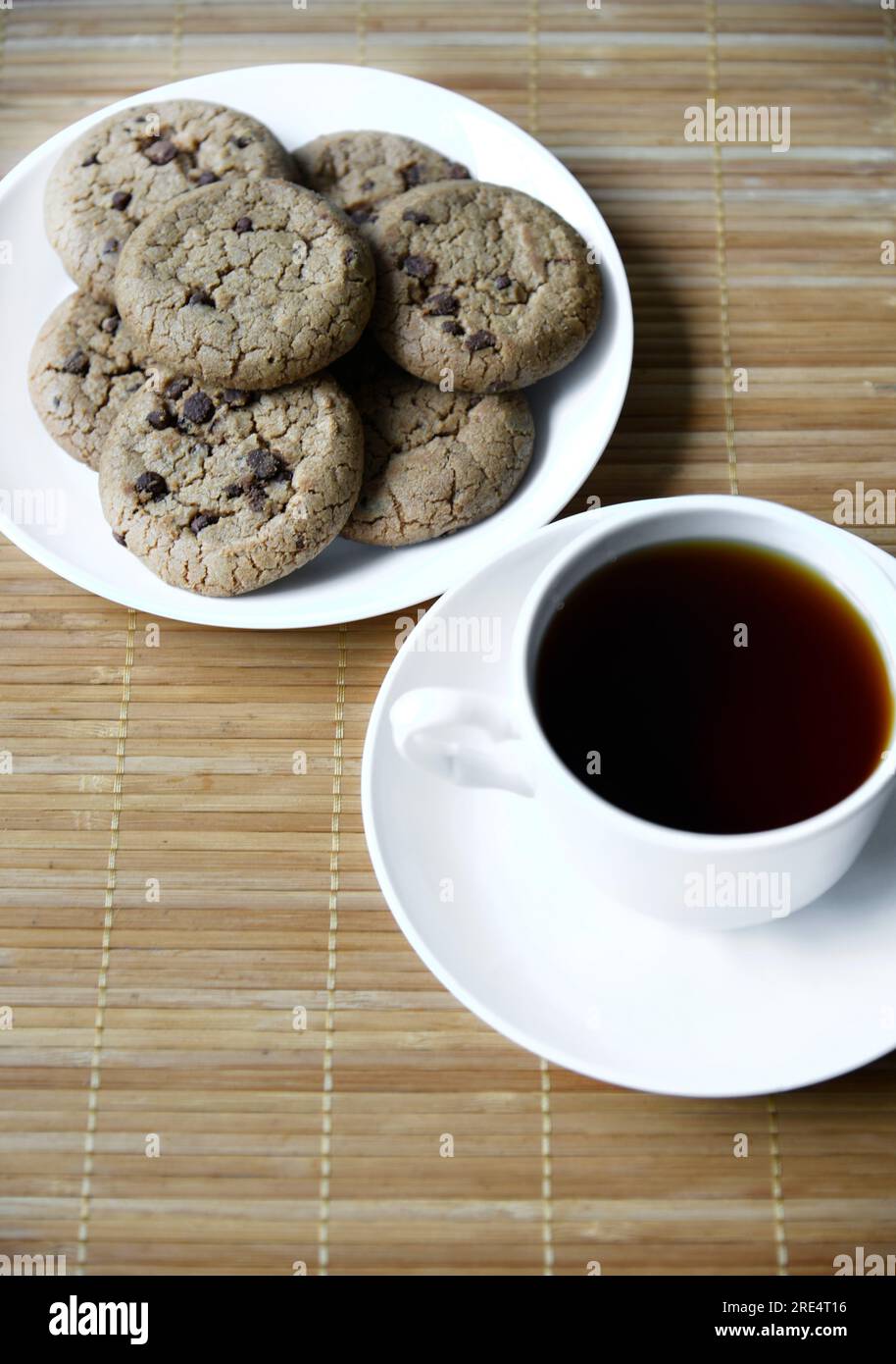 Tea pair and oatmeal cookies with chocolate on a mat. Delicious