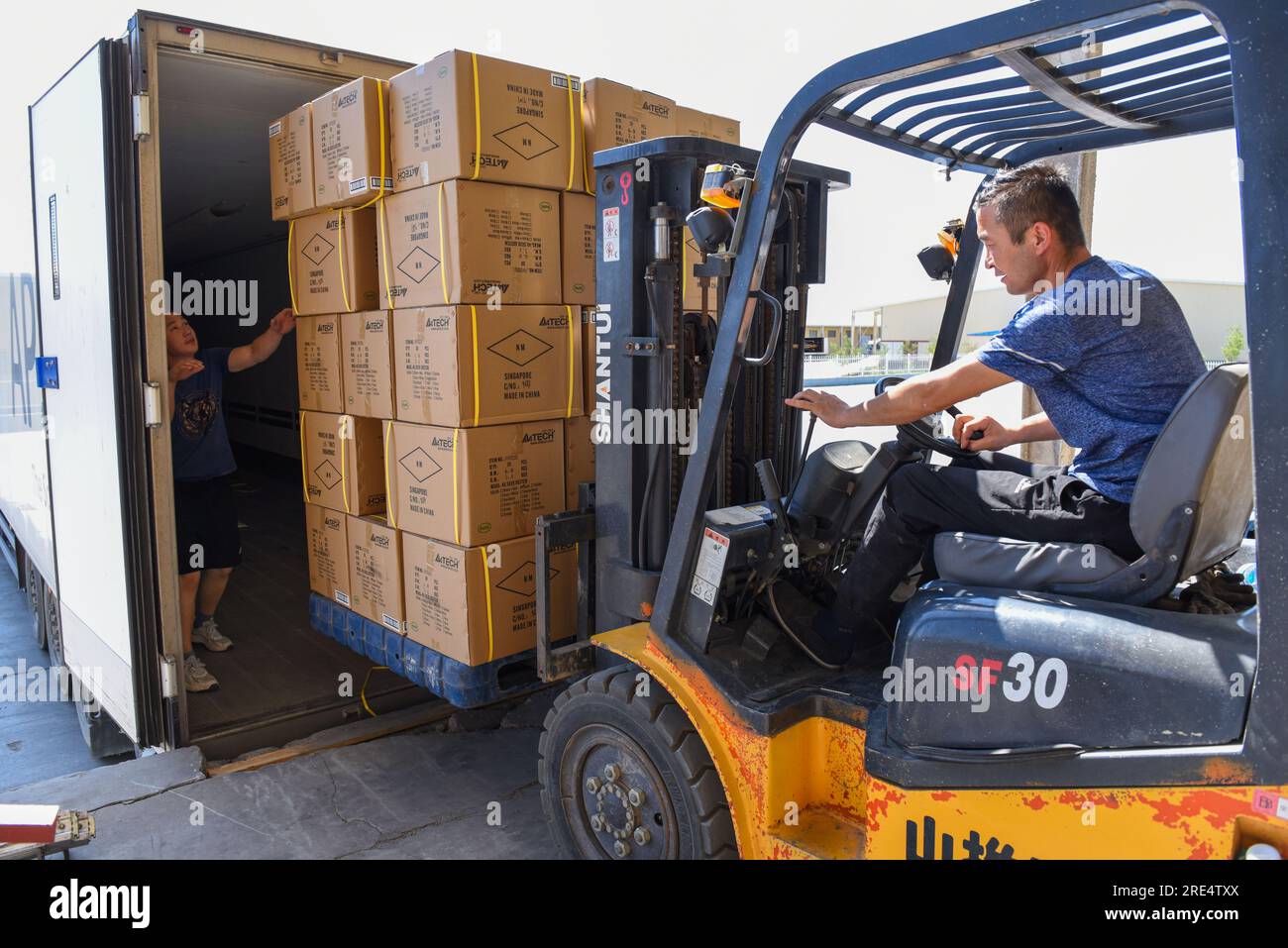 (230725) -- ALATAW PASS, July 25, 2023 (Xinhua) -- Staff members load cargo onto a truck at the custom clearance center for the cross-border e-commerce of the Alataw Pass comprehensive bonded area in northwest China's Xinjiang Uygur Autonomous Region, July 24, 2023. In recent years, various measures have been taken to create a better business environment for cross-border e-commerce enterprises in Alataw Pass. The cross-border e-commerce business was launched in the inland port in northwest China's Xinjiang Uygur Autonomous Region in January 2020. In the first half of this year, more than 14.50 Stock Photo