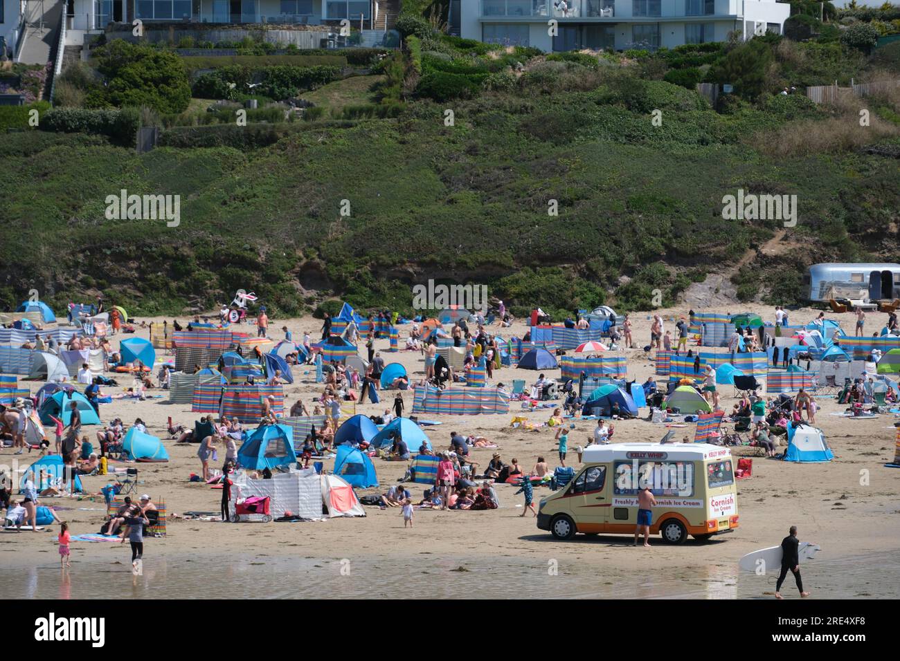Polzeath, Cornwall, UK. 25th July 2023. UK Weather. With a sea breeze and temperature of 21 degrees C it was pleasant afternoon on a busy beach at Polzeath in North Cornwall today. Credit Simon Mayock / Alamy Live News. Stock Photo