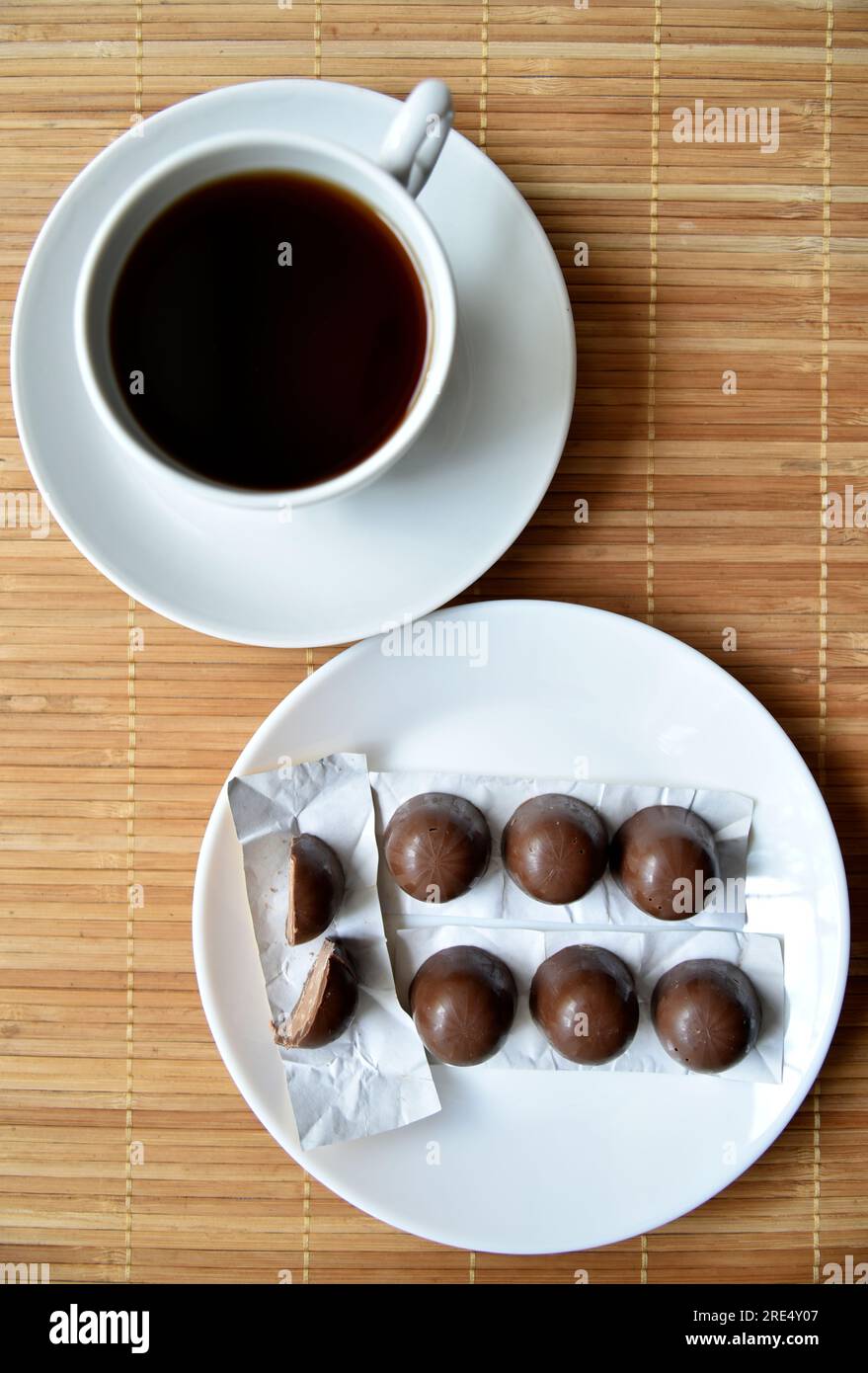 Tea couple on a mat with chocolate bars. A porcelain cup and saucer and tea with sweets. Art design. Stock Photo