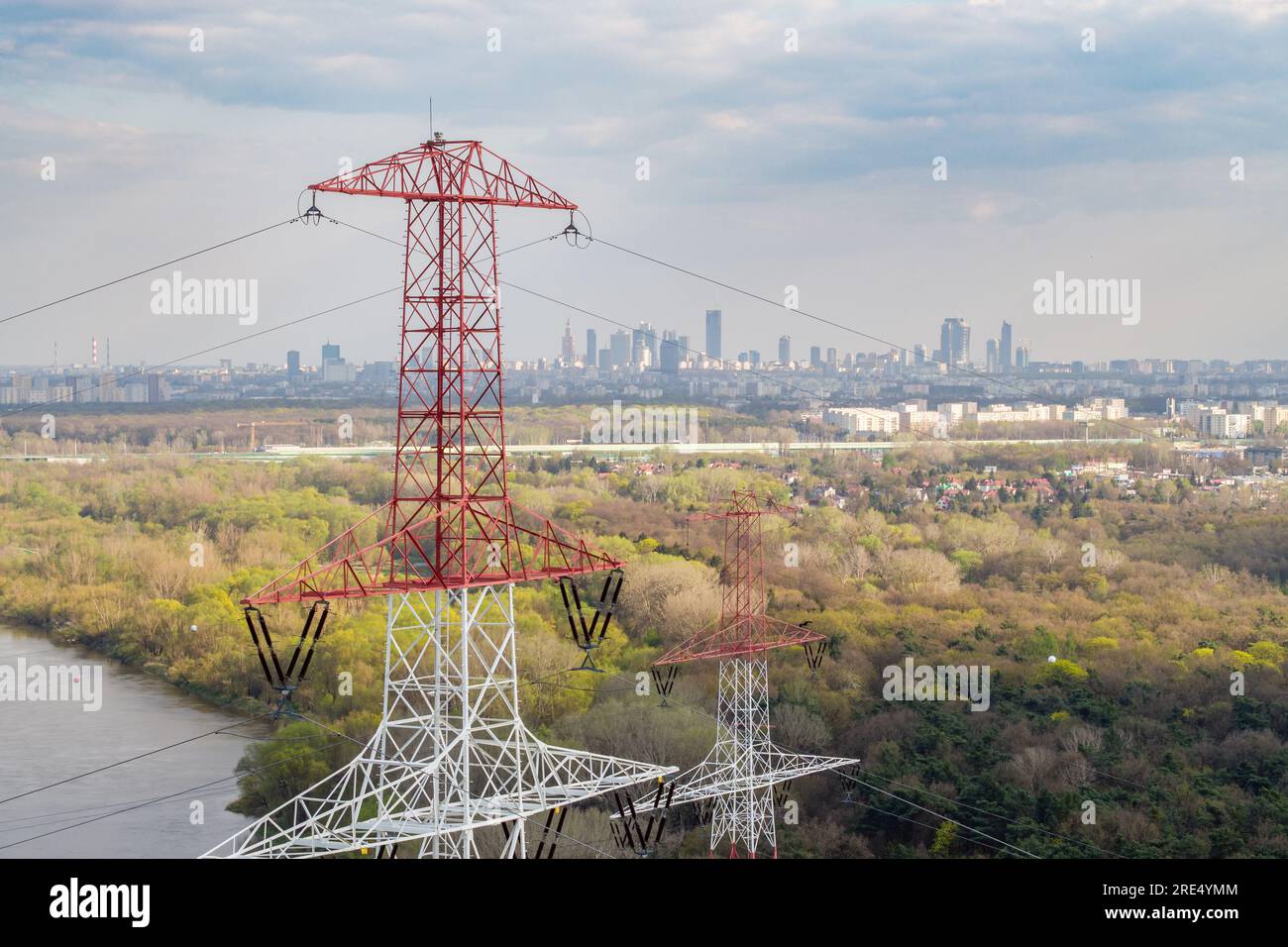 Aerial view of electricity pylon and high voltage line against city center Stock Photo