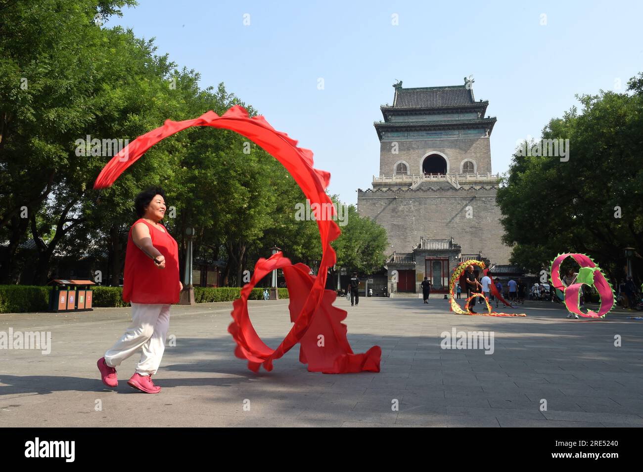 (230725) -- BEIJING, July 25, 2023 (Xinhua) -- People exercise in front of the Bell Tower in Beijing, capital of China, July 18, 2023.  First created in the Yuan Dynasty (1271-1368), the Beijing Central Axis, or Zhongzhouxian, stretches 7.8 kilometers between the Yongding Gate in the south of the city and the Drum Tower and Bell Tower in the north. Most of the major old-city buildings of Beijing sit along this axis.   Gates, palaces, temples, squares and gardens of the old city are all linked up to the axis. As they witnessed the folk activities along the line from old days to new ones, they t Stock Photo