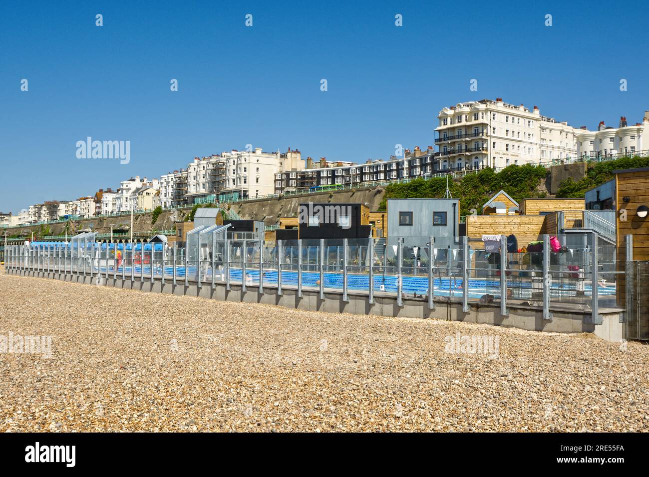 New swimming pool. restaurants and cafes on the beach at Brighton, East Sussex, England. With people in pool and cafe. Stock Photo