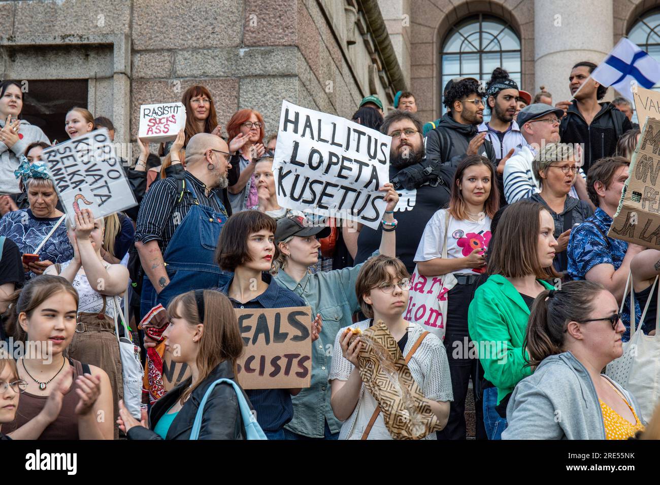 Protesters holding handmade signs on Parliament House steps at Nollatoleranssi! Rasistit ulos hallituksesta demonstration in Helsinki, Finland Stock Photo