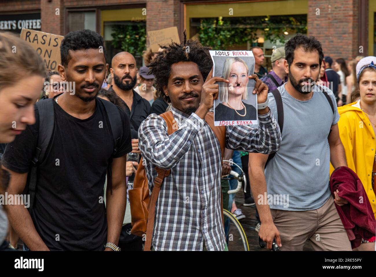 Anti-racism demonstrator holding a defaced image of Riikka Purra, Minister of Finance, at Nollatoleranssi! protest in Helsinki, Finland Stock Photo