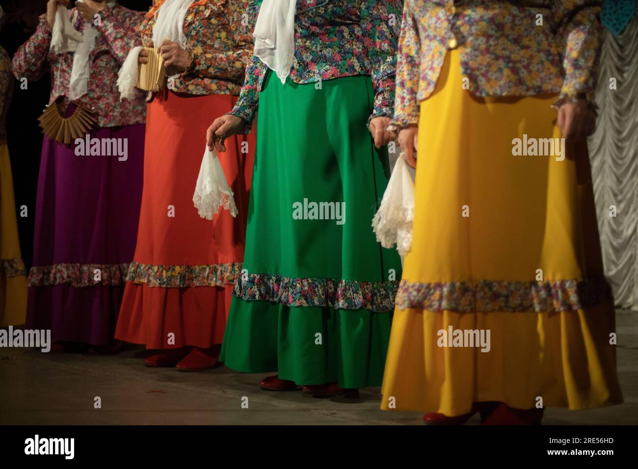 Folk costumes. Women perform on stage. Folklore ensemble. Beautiful