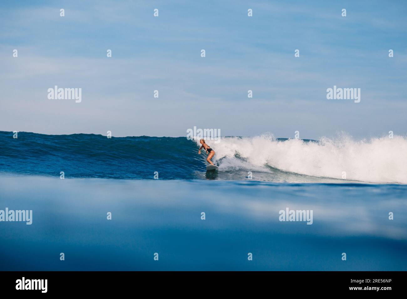 Surfer woman ride on ocean wave on surfboard. Woman during surfing with ...