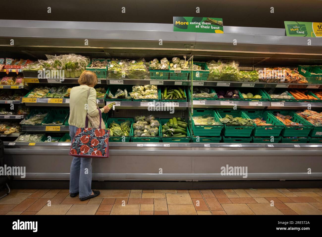 A woman shops for vegetables at a Morrisons supermarket as food prices continue to rise due to the highest inflation rates in the UK since the 1970's. Stock Photo