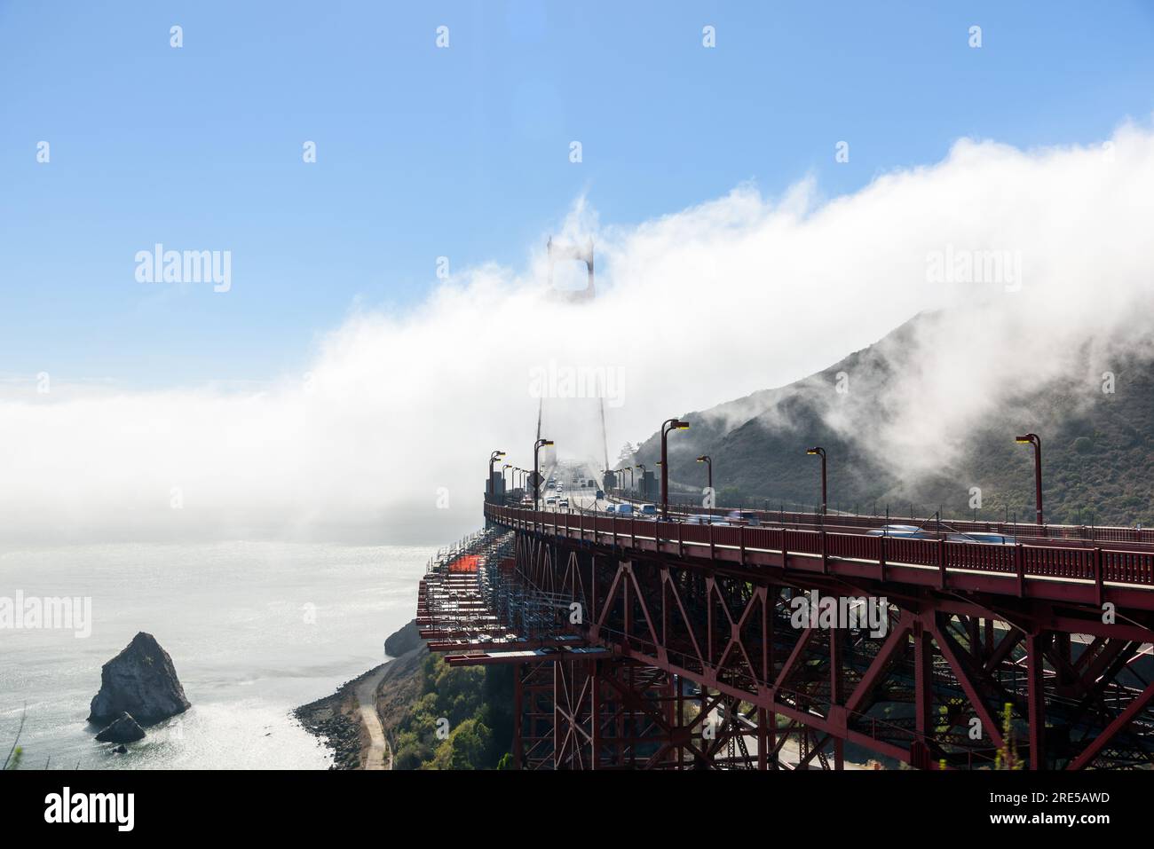 Traffic on Golden Gate bridge partly shrouded in fog on an autumn ...