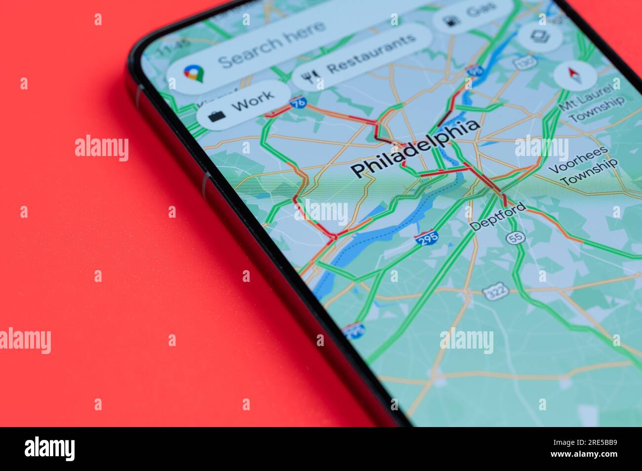 New York, USA - July 21, 2023: Car traffic on Philadelphia google maps on smartphone screen close up view with red background Stock Photo