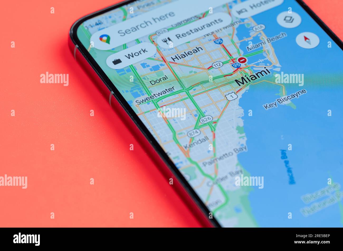 New York, USA - July 21, 2023: Car traffic on Miami google maps on smartphone screen close up view with red background Stock Photo