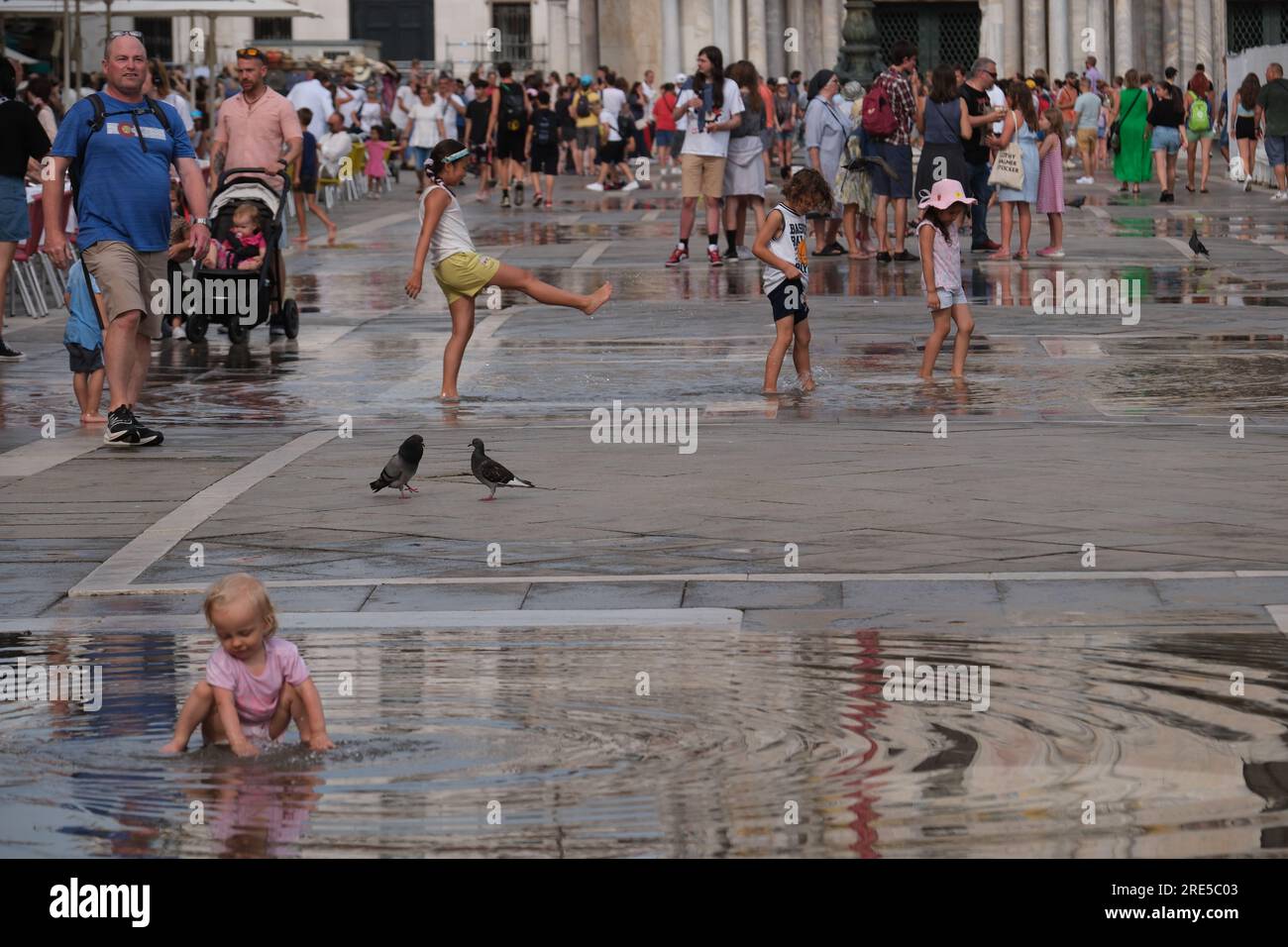 children play in the water during an nusually high water period in Venice Stock Photo