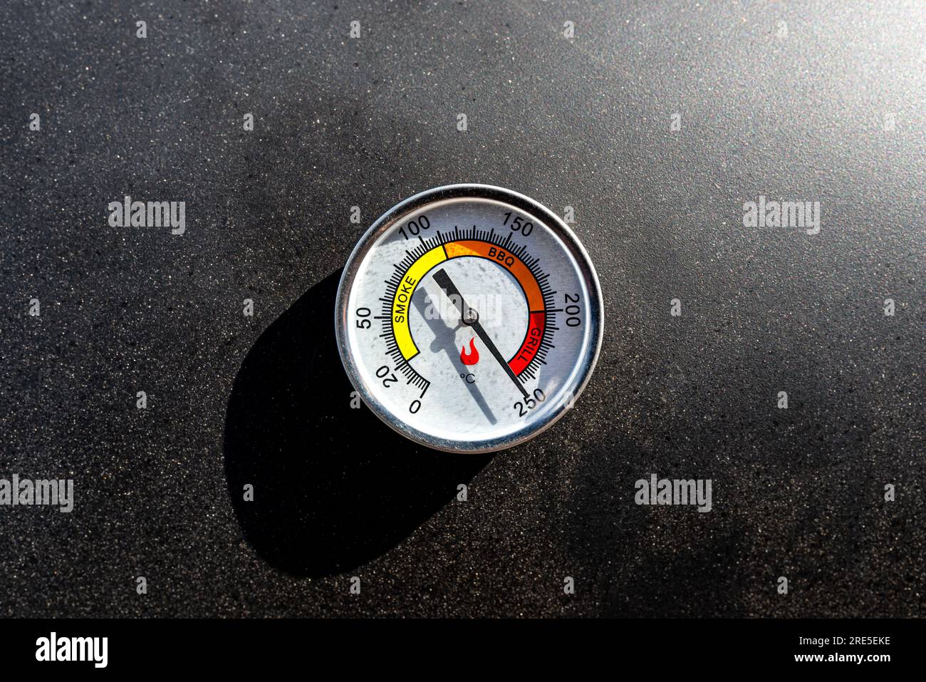 A round thermometer showing 250 degrees Celsius placed on a charcoal grill Stock Photo Alamy