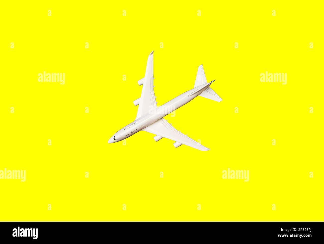 White plane, airplane in yellow color. Rainbow gradient background with copy space. Top view, flat lay. Minimal style design. Travel, vacation concept Stock Photo