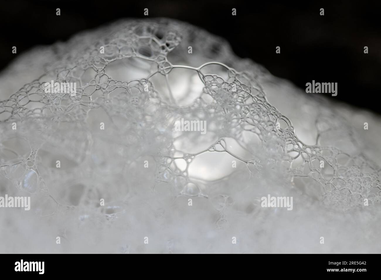 Soap bubble foam macro on black background. White soft foam Stock Photo