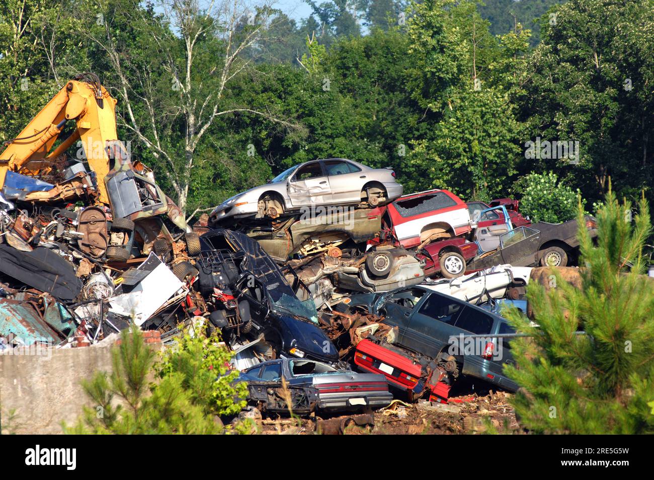 A pile of wrecked cars and auto bodies are crushed and stacked for