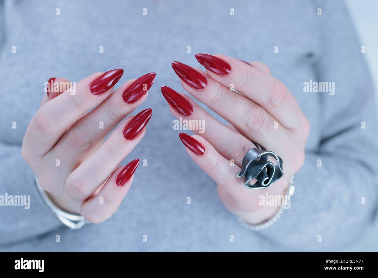 Woman hand with long nails and a bottle of dark red burgundy nail polish  Stock Photo - Alamy