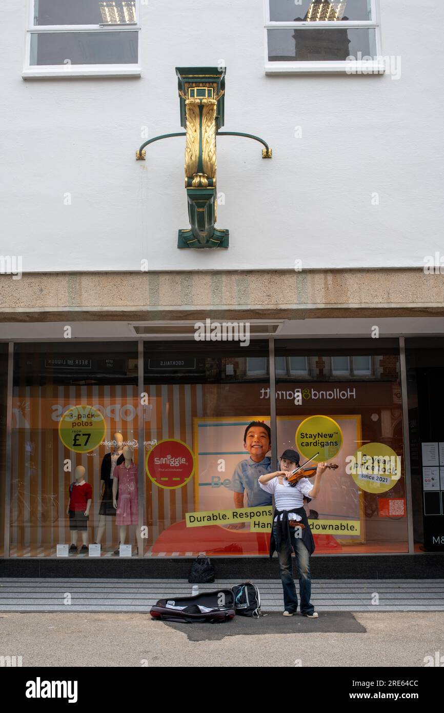 Violinist plays outside Marks and Spencer in Oxford City Centre Stock