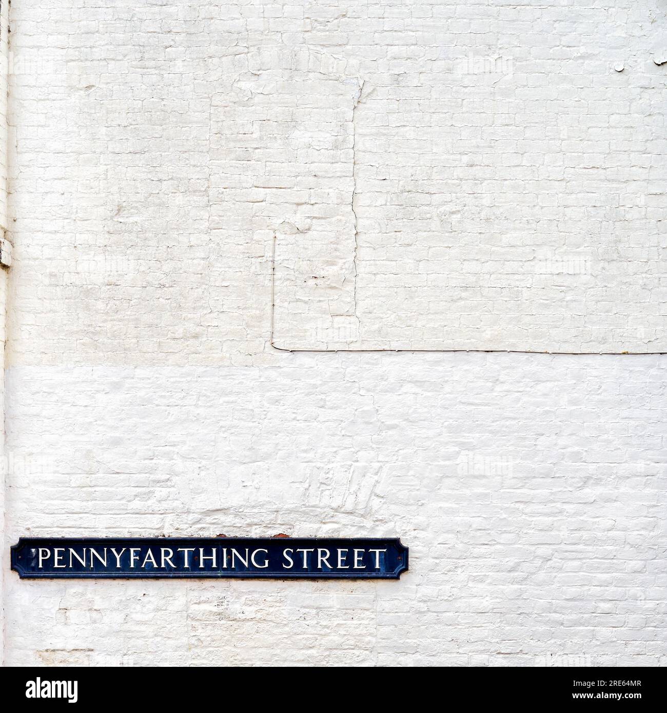 Pennyfarthing street sign on white painted brick wall Stock Photo