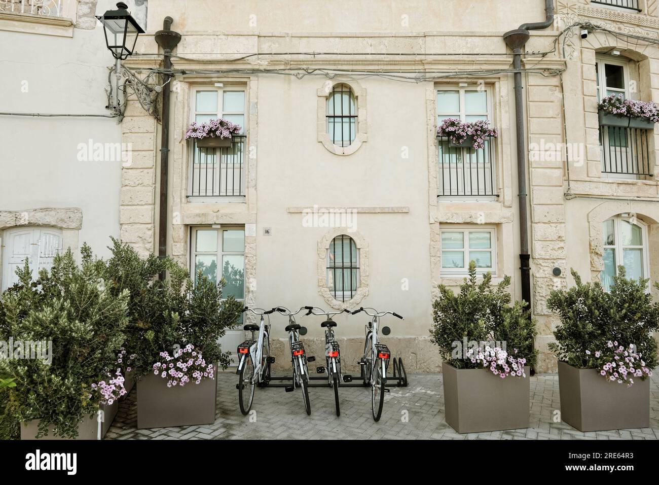 bicycles in front of a beautiful facade of old house ornate with flowers in Ortigia, Siracusa, Sicily, Italy Stock Photo