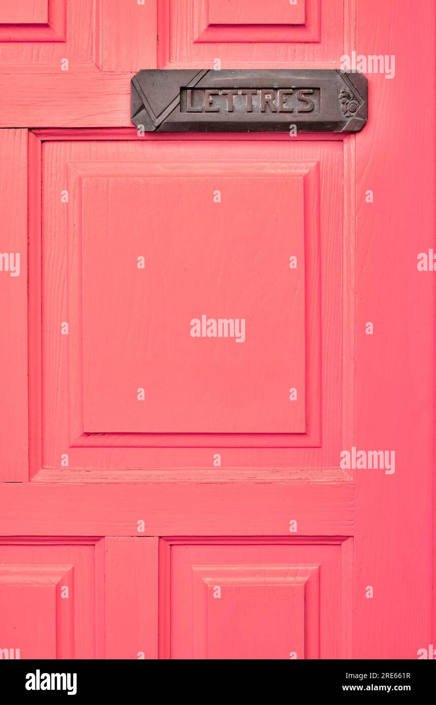 Pink door with a letter box and a French word LETTRES (English: MAIL
