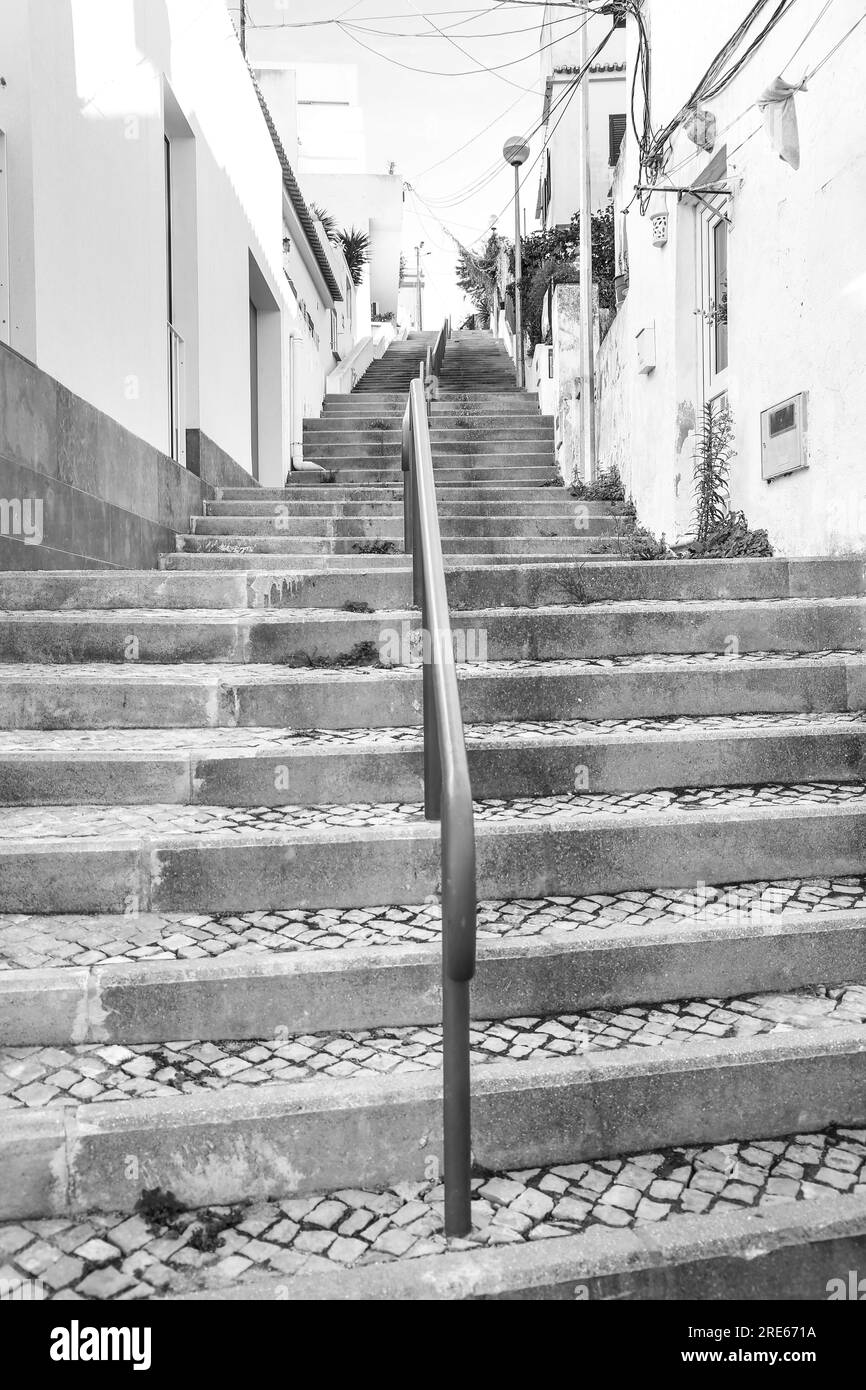 Ferragudo, Portugal- October 20, 2022: Narrow Cobblestone streets and stone staircase in Ferragudo town, Portugal Stock Photo