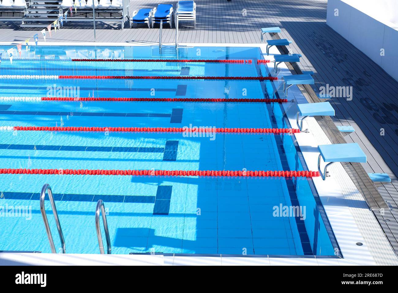 A blue swimming pool with starting platforms, swimming lanes markings