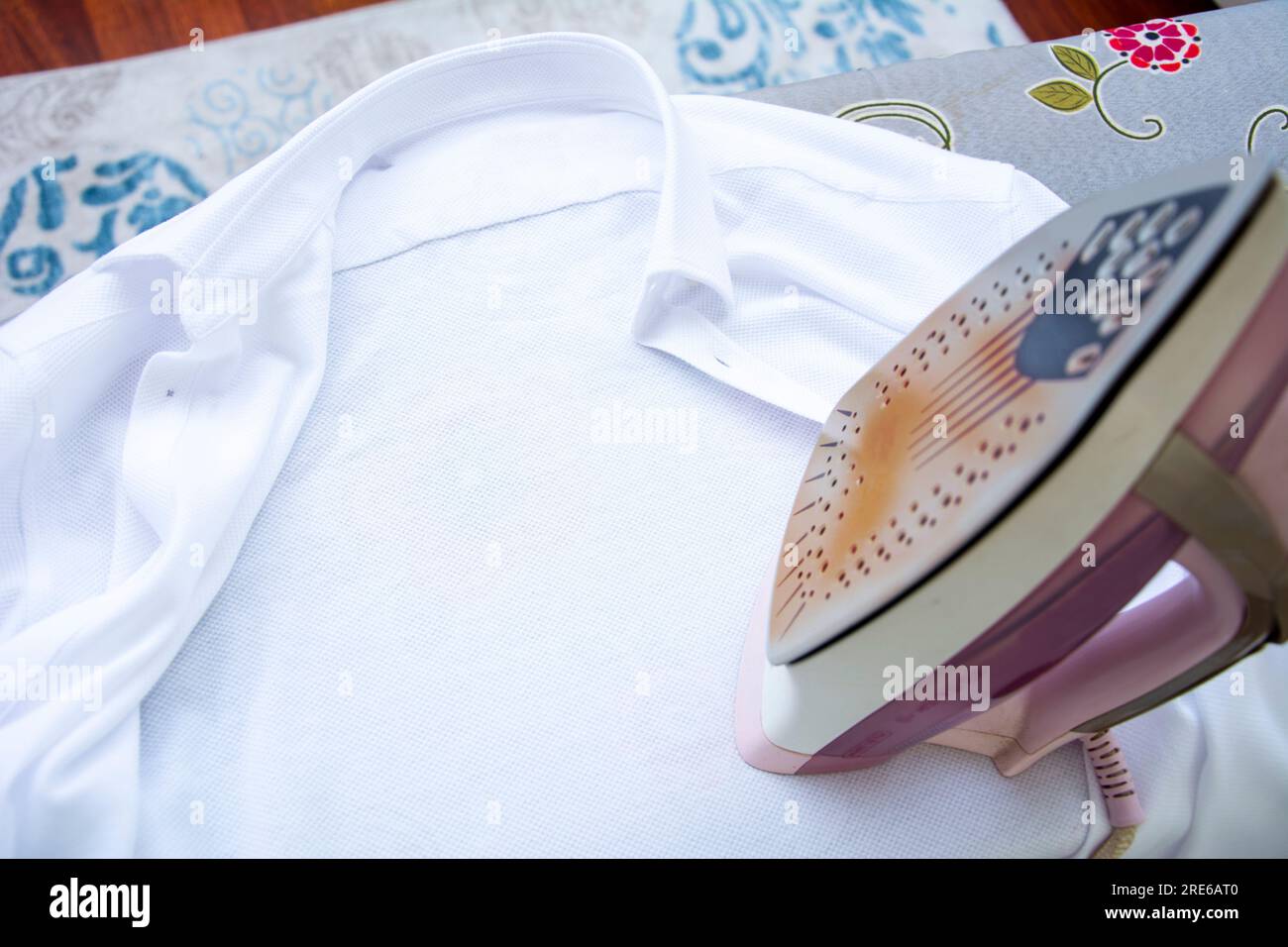 Ironing a shirt with a rusty iron Stock Photo