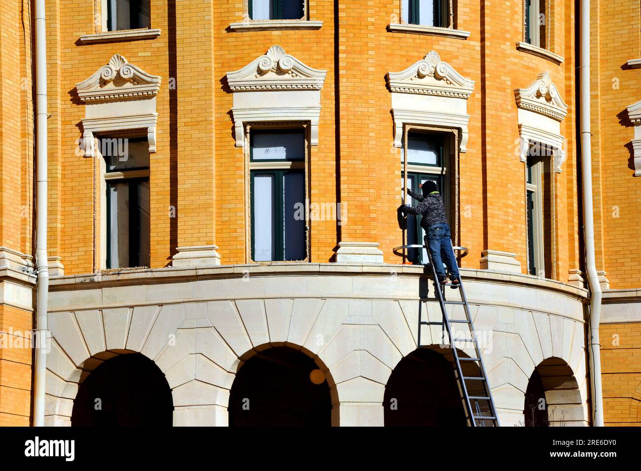 Harrison County Courthouse in Marshall, Texas gets a facelift as it completes decorations for Christmas.  Worker is repainting window trim and lights Stock Photo